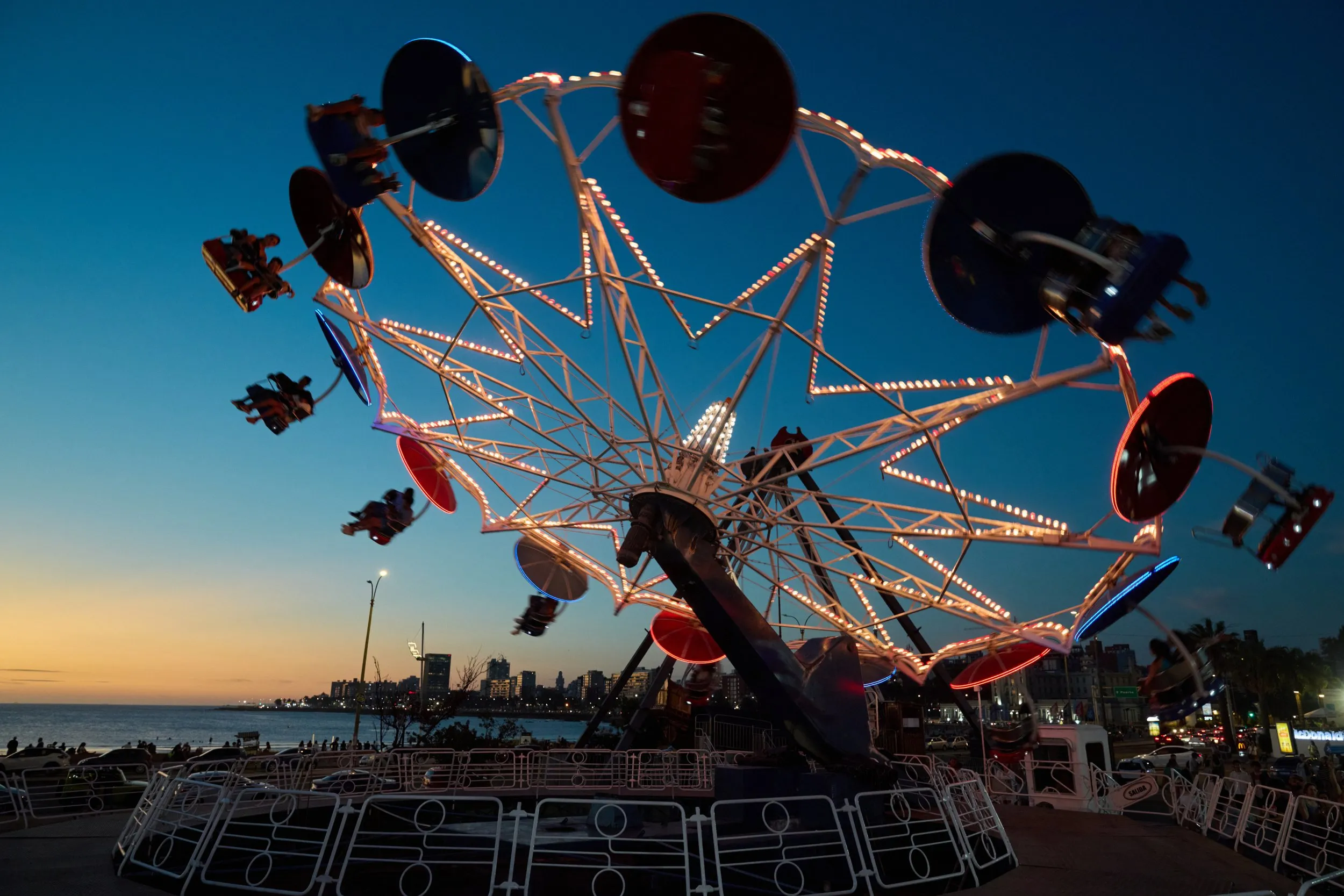 Las sillas voladoras del Parque Rodó encendidas contra el cielo del atardecer