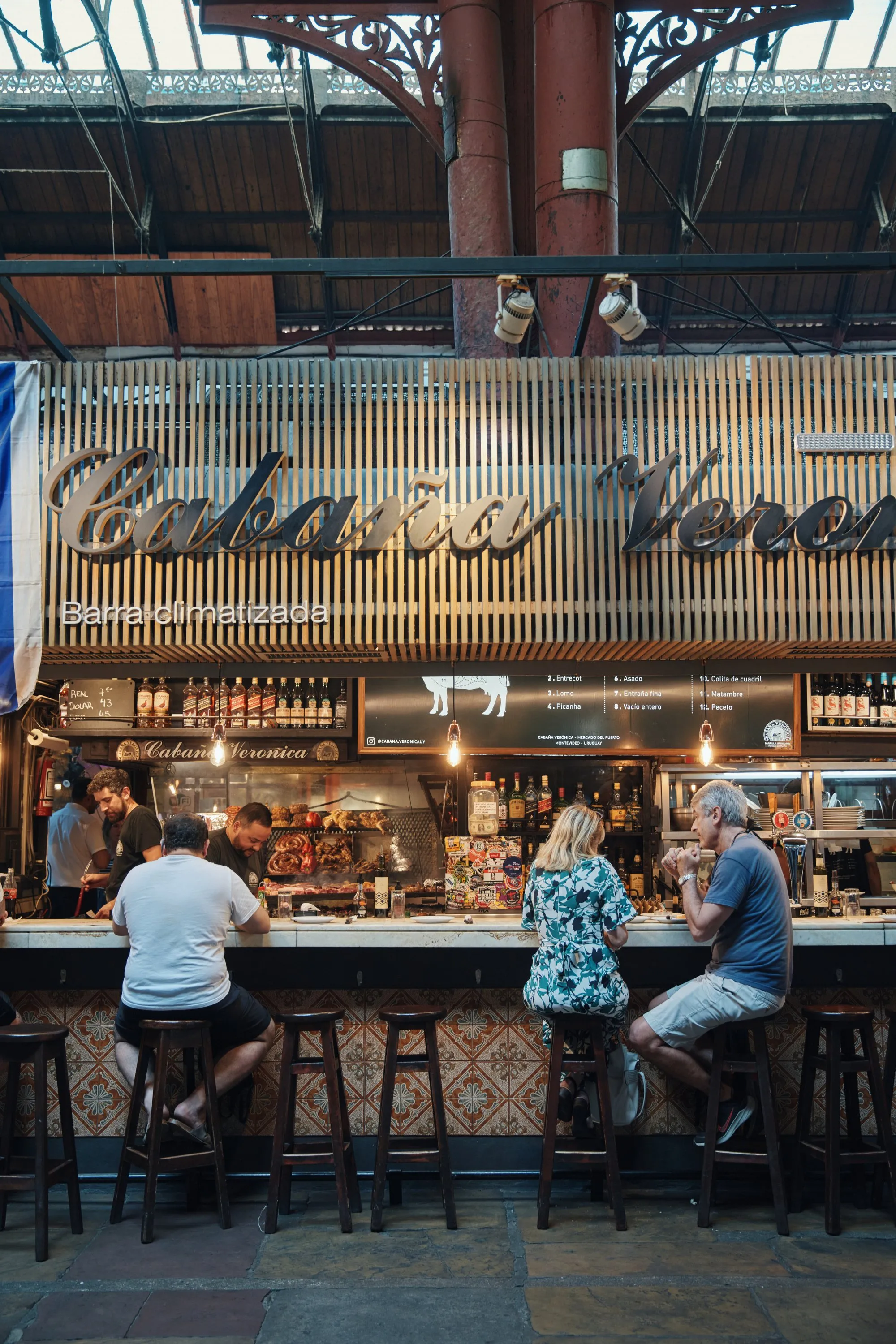 El mostrador de la Cabaña Verónica en el Mercado del Puerto, con la gente comiendo