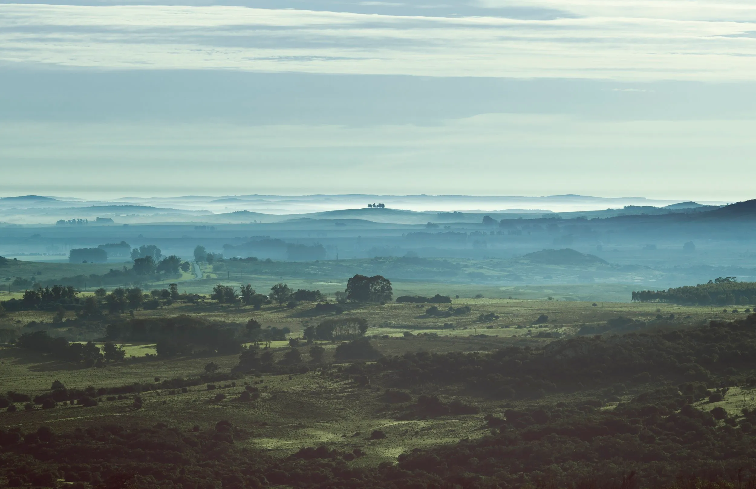 Las lomas de Villa Serrana en capas azuladas, en la bruma del amanecer