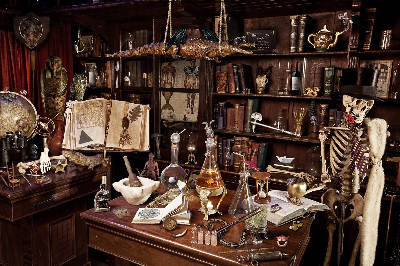 Una habitación llena de objetos de ciencias, historias y misterio, con estanterías llenas de libros, esqueletos decorativos, frascos con líquidos, y objetos antiguos y rituales.