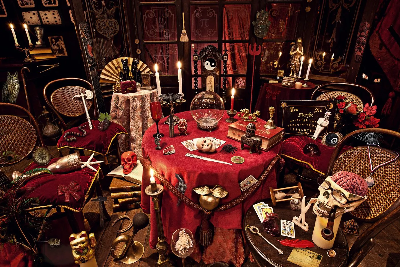 Una mesa decorada con objetos místicos y esotéricos en una habitación oscura, con velas encendidas, libros antiguos y adornos misteriosos.